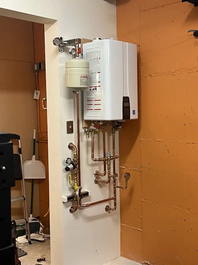 Plumbing technician inspecting water heater connections in Somers Point